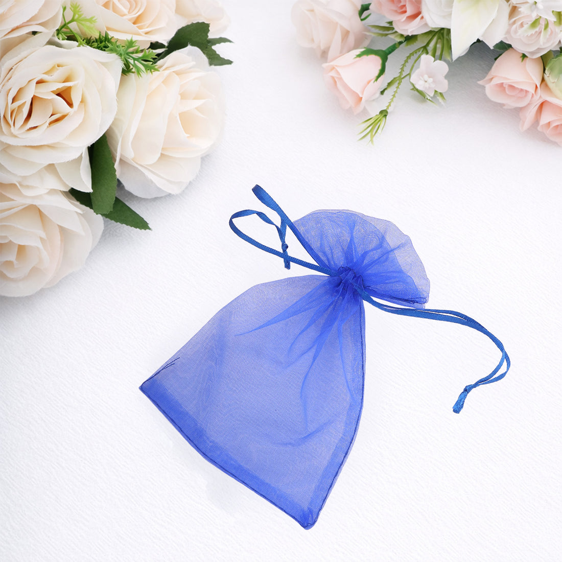 Blue organza drawstring bag on a white background