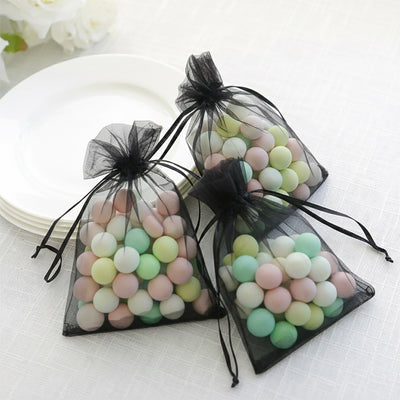 Colorful candy-filled organza bags on a table.