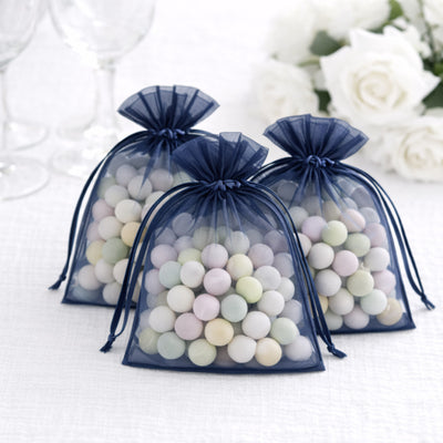 Three navy blue organza bags filled with pastel-colored candies.