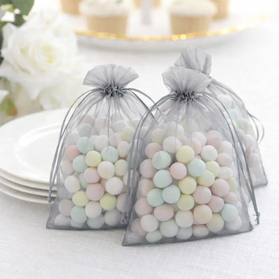 Pastel candy-filled favor bags on a table setting.