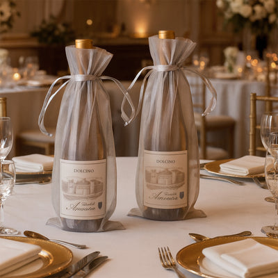 Elegant wine bottles in sheer bags on a beautifully set dining table.