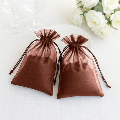 Two elegant brown organza drawstring bags on a light surface.