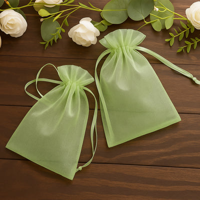 Green organza gift bags on a wooden surface