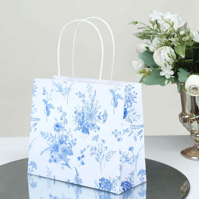 Floral-patterned gift bag with white and blue design on a reflective surface.