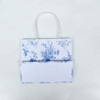 Blue floral gift bag with envelope on a plain white background