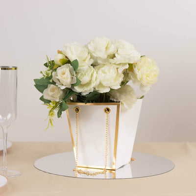 White floral arrangement in a stylish gold-accented pot.