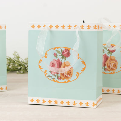 Floral-patterned gift bag with ribbon handles in mint green.