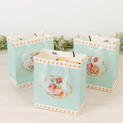 Three decorative gift bags with floral design on a light backdrop.