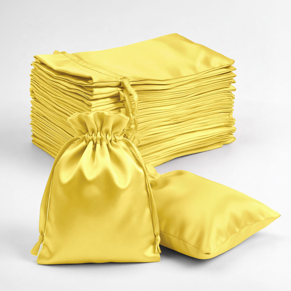 Stack of yellow satin bags on a white background.