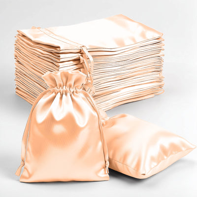 Set of peach satin drawstring bags on a white background.