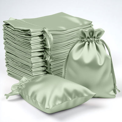 Green satin drawstring bags stacked and arranged on a white background.