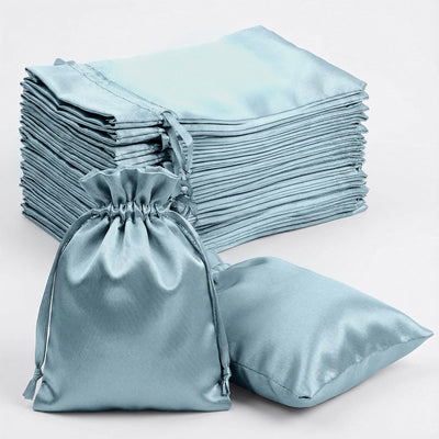 Stack of light blue satin bags and a flat pouch on a white background.