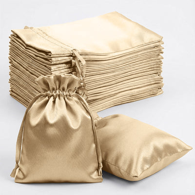 Set of gold satin drawstring bags on a plain background.