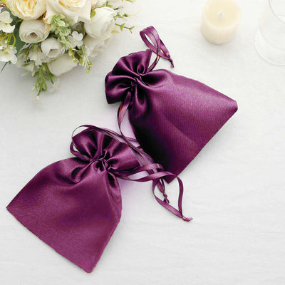 Purple satin gift bags with drawstrings on a light background.
