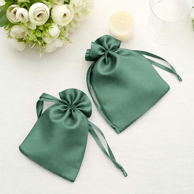 Green satin drawstring bags on a soft background.