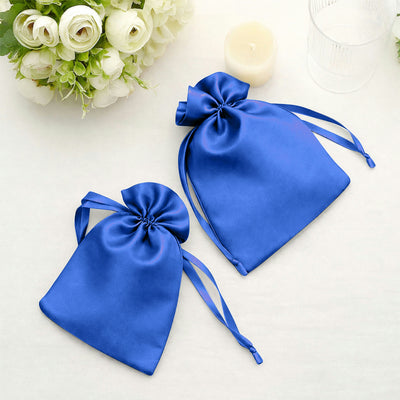 Blue satin drawstring bags on a light surface with floral accents.