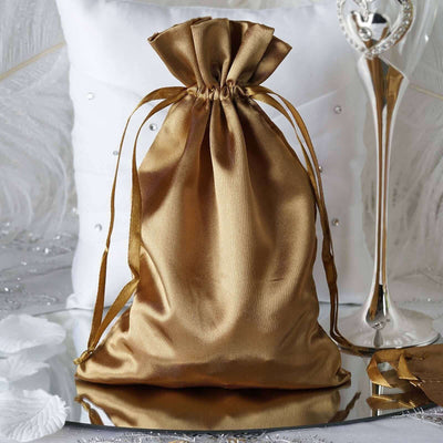Gold satin drawstring bag on a reflective surface.