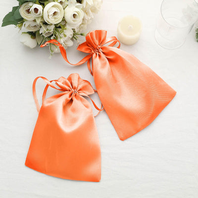 Two elegant orange satin gift bags with drawstrings.