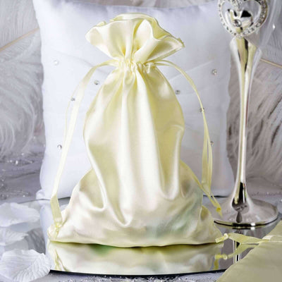 Yellow satin drawstring bag on a reflective surface with decorative elements.