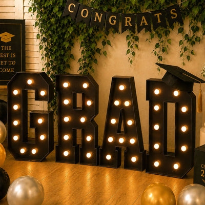 Graduation party decor with giant illuminated congrats letters and balloons