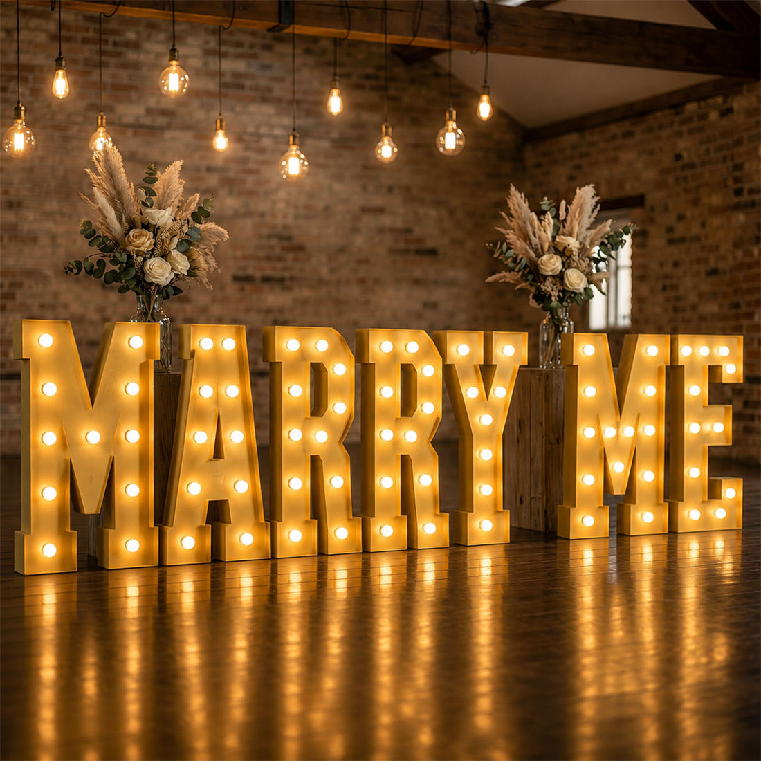 Large illuminated “MARRY ME” wedding proposal sign with floral arrangements indoors