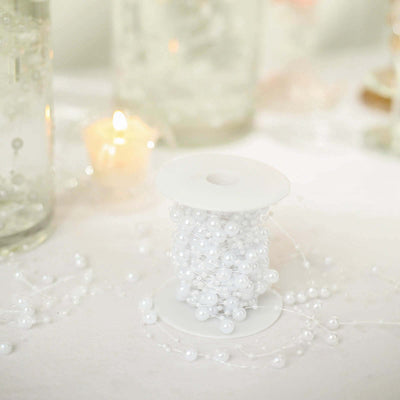 White pearl bead spool on a table with candlelight in the background.
