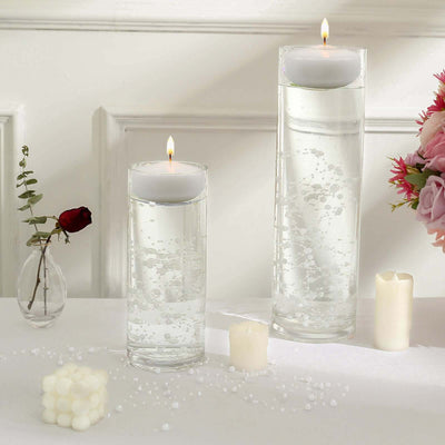 Elegant glass candle holders with floating candles and decorative elements.