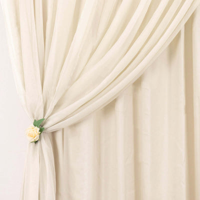 Cream sheer curtain draped elegantly with floral tieback.