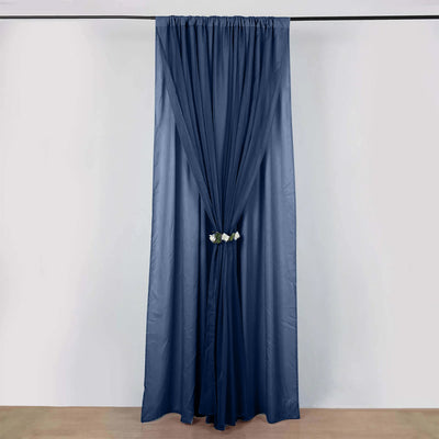 Navy blue curtain with floral tieback on plain background