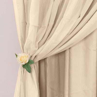 Cream curtain draped with a decorative rose clip.