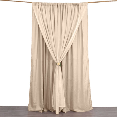 Beige pleated curtain with tieback on a plain backdrop.
