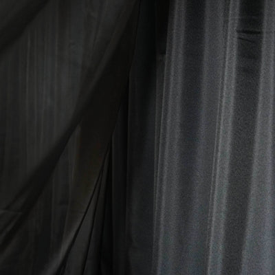Black sheer fabric draping elegantly in soft folds.
