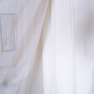 Sheer white fabric draping elegantly in soft natural light.