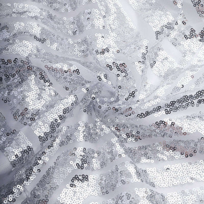 Silver sequin fabric with shimmering details on a white background.