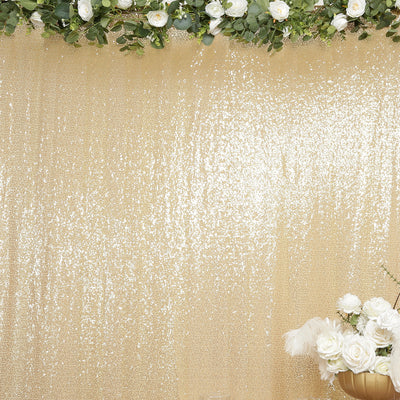 Gold sequin backdrop with floral arrangement at the bottom.
