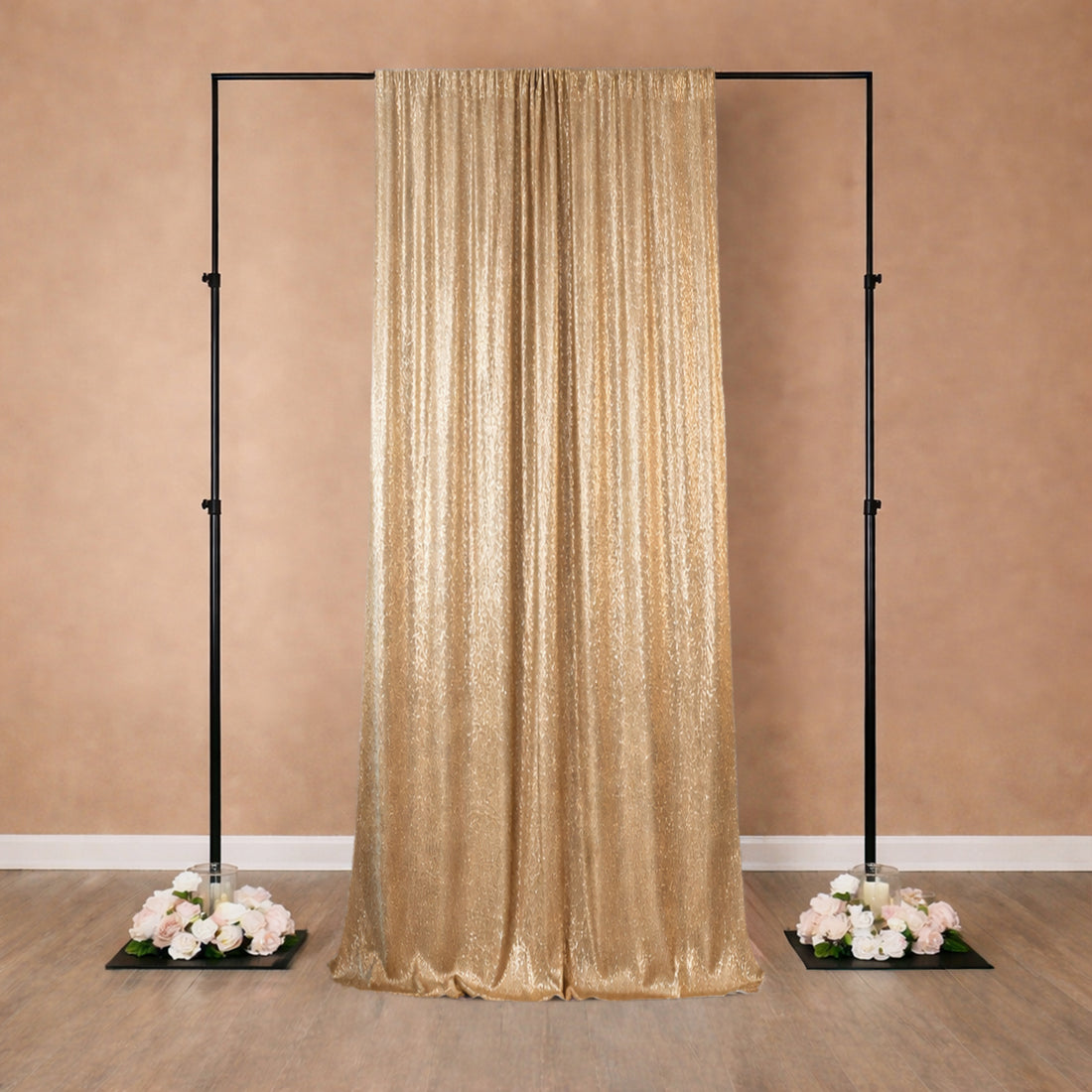 Gold sequin backdrop with floral bases for event decoration.