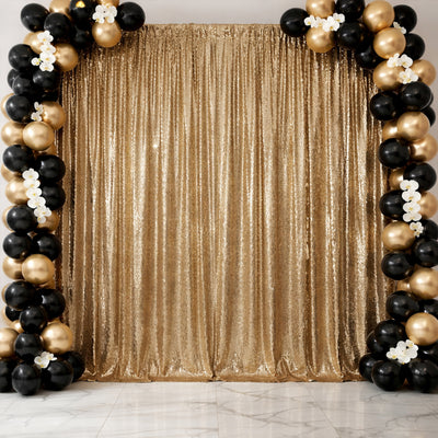 Gold sequin backdrop with black and gold balloons for event decoration.