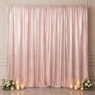 Rose gold sequin backdrop with candles and floral arrangements.