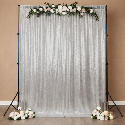 Silver sequin backdrop with floral accents for events and photography.