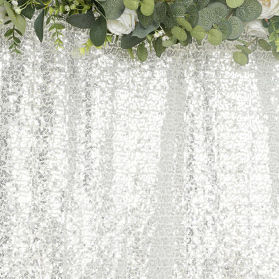 Elegant white lace tablecloth with floral arrangement detail.