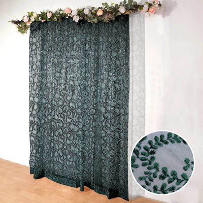 Green embroidered lace curtain with floral design on a white backdrop.