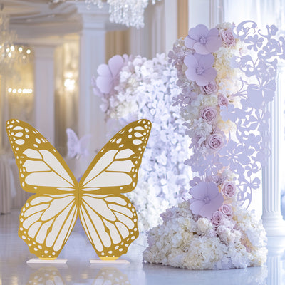 Gold butterfly decoration with floral backdrop in elegant venue.