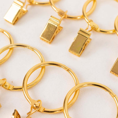 Gold clip-on earrings with circular hoops and rectangular charms.
