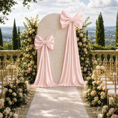 Elegant outdoor wedding altar with pink drapes, bows, and floral arch decor