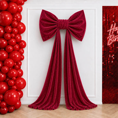 Red velvet bow and draped curtain backdrop with balloon birthday decor