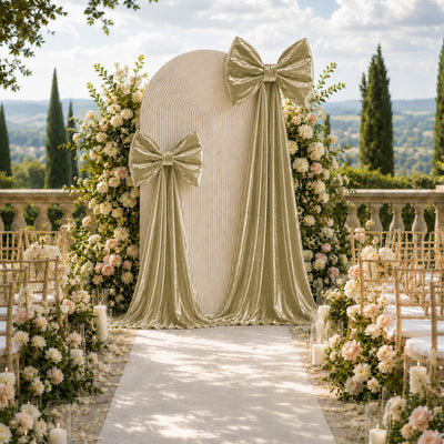 Elegant outdoor wedding ceremony backdrop with floral arches and velvet bows