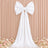 Elegant white bow wedding backdrop with floral arrangement and draped fabric