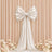Elegant white satin bow on blush pleated backdrop with floral wedding decor