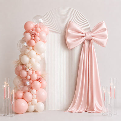 Pastel pink balloon arch with satin bow wedding or baby shower backdrop