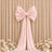 Pink satin bow backdrop with flowing drapes and flowers for elegant event decor